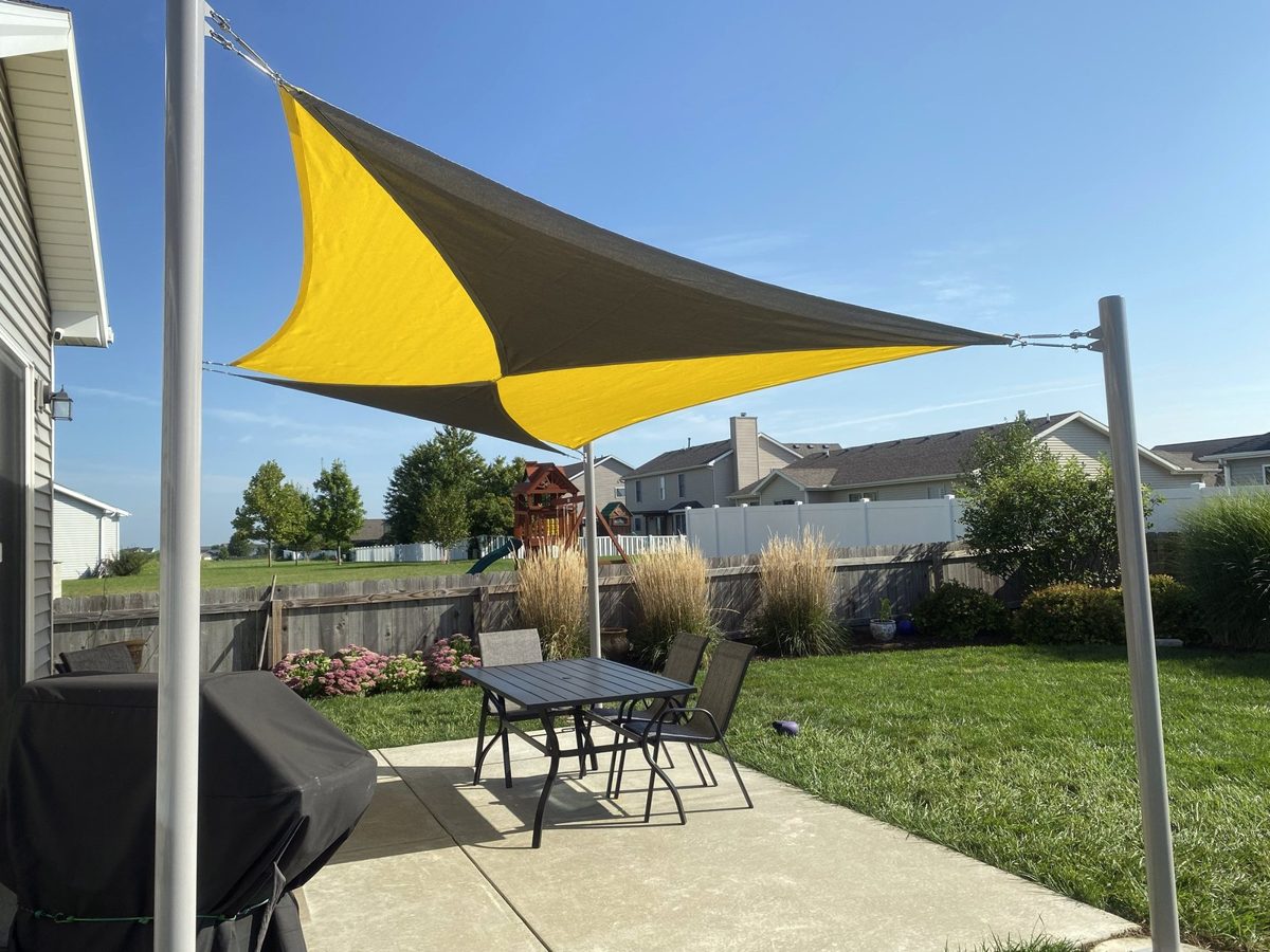 Yellow and grey two-tone sail over a backyard patio