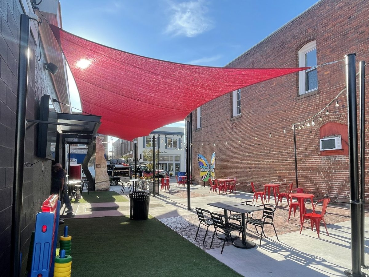 Red sail over an outdoor seating area