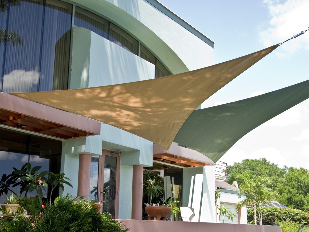Tan and green triangle sails off a building