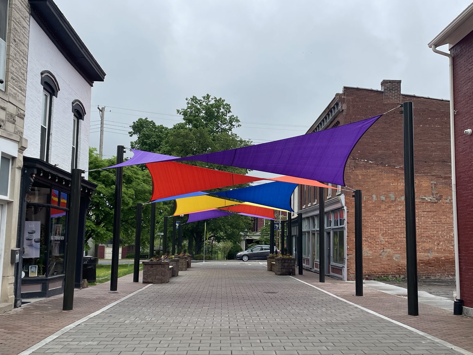 Layered sails with hypar twists over a downtown walkway
