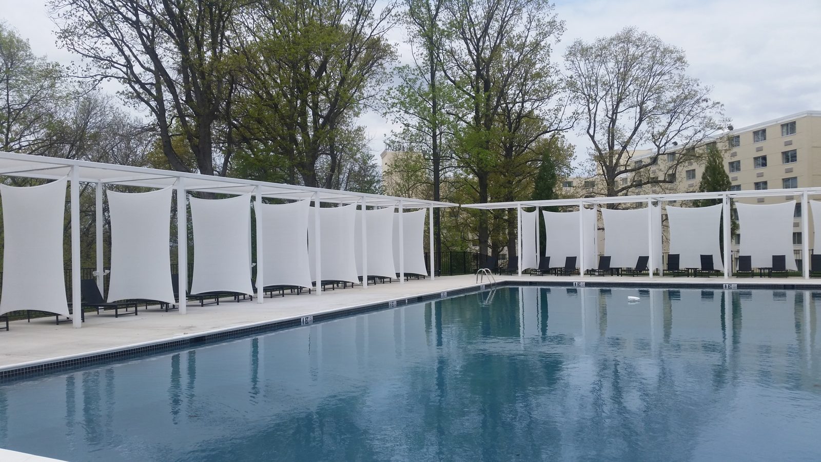 White rectangle sail panels lining a pool deck