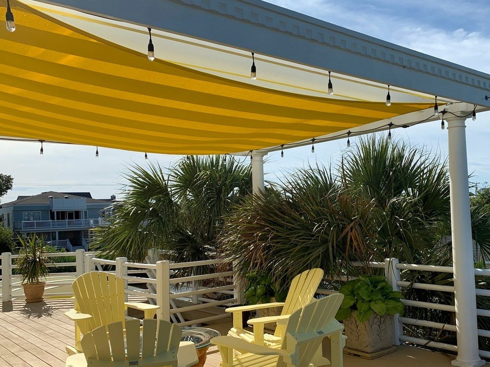 Yellow shade sail over a waterfront deck