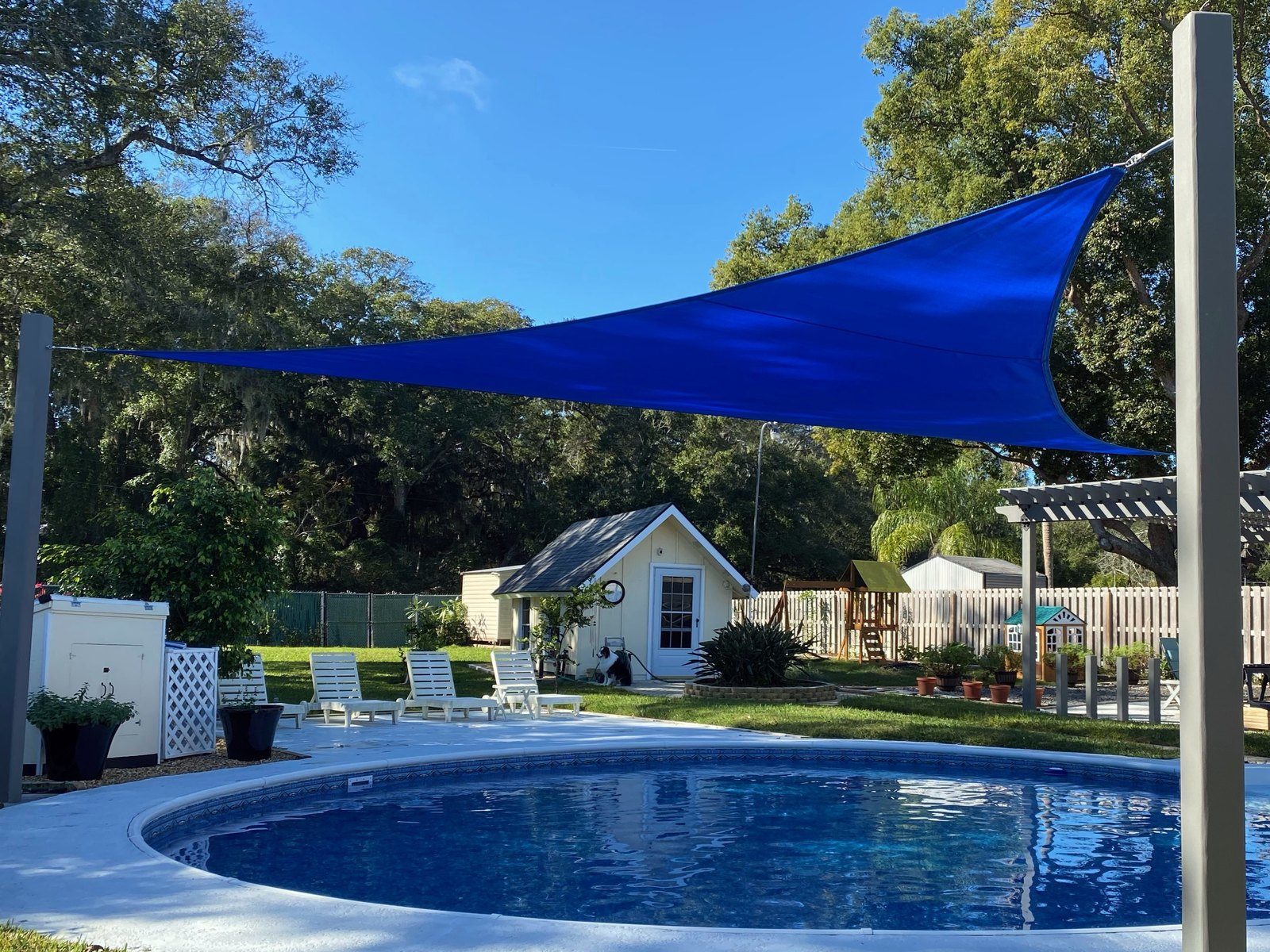 Blue triangle shade sail over a backyard pool